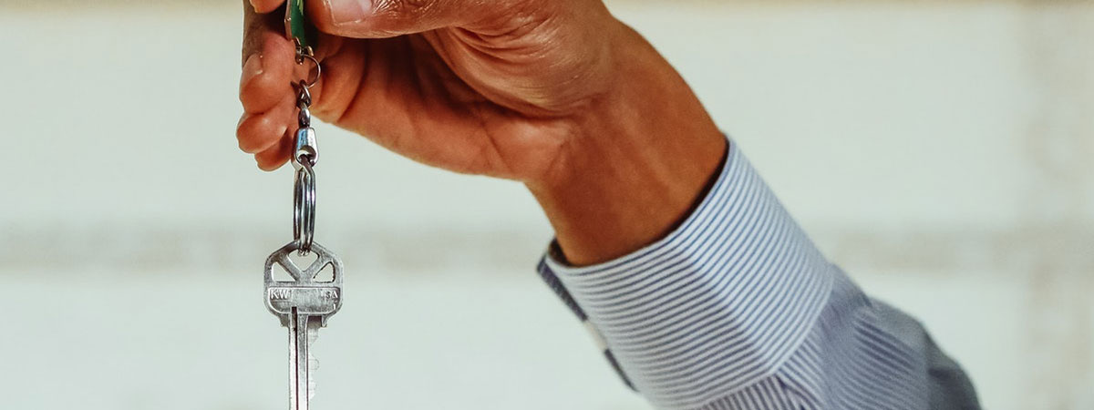 hand holding a pair of keys for their tenants
