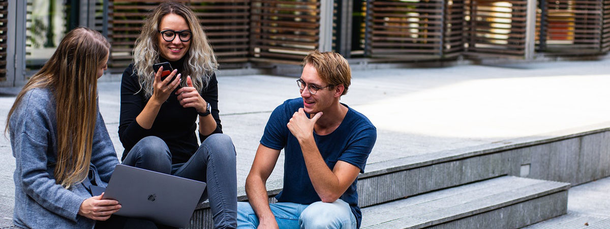 three people sitting on concrete steps