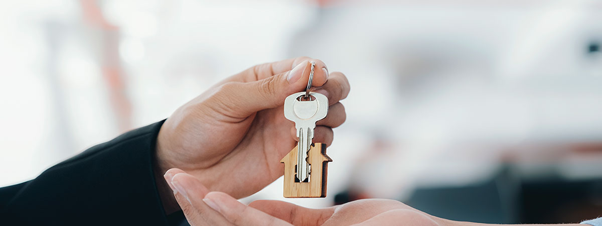 one hand giving a pair of keys to another hand 