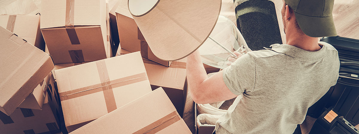 moving out of a home, man packing a lamp