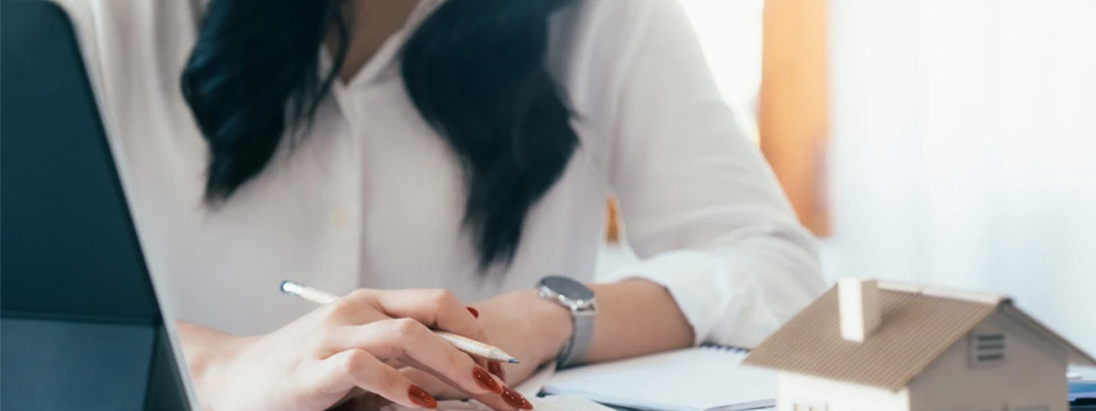 Woman calculating the cost of buy to let mortgage and completing paperwork.