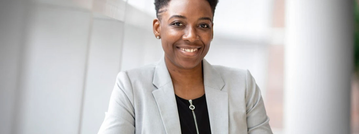 A smartly-dressed property manager is smiling at the camera 