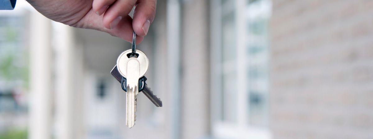 An accidental landlord holds house keys in their hand