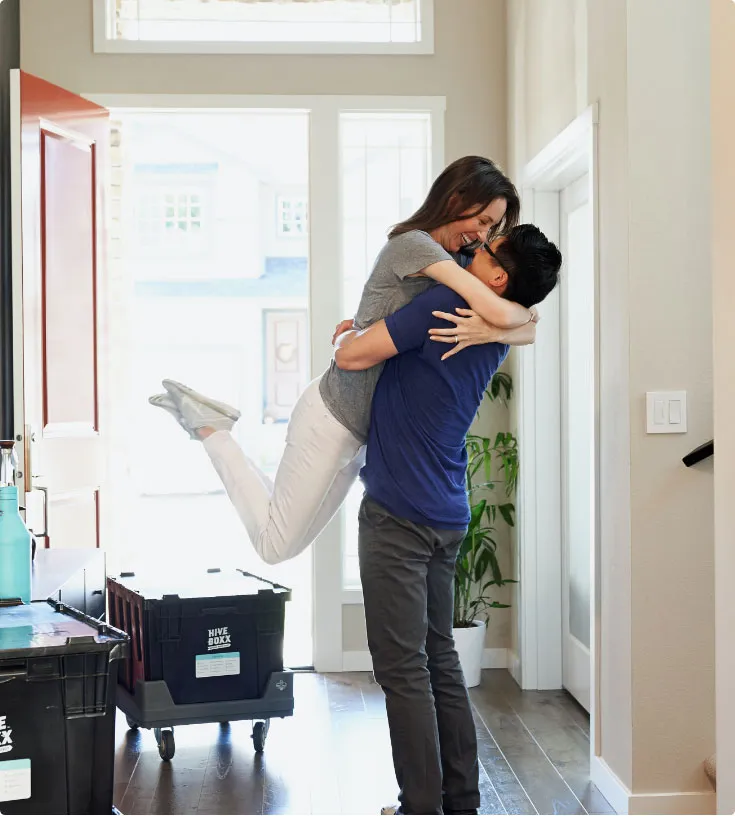 A couple moving into their new home hugging each other in a joyful moment