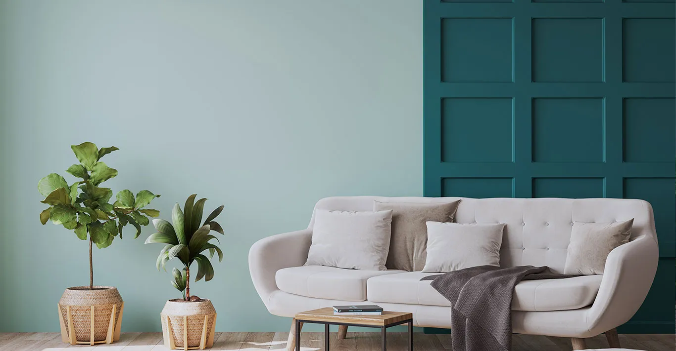 A beautiful London apartment with green walls and a velvet cream sofa in it