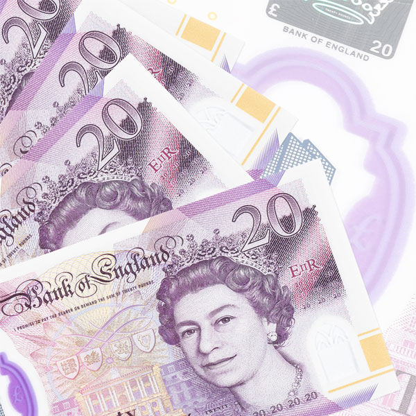 lots of 20 pound notes spread out on a table to represent the money earned from guaranteed rent