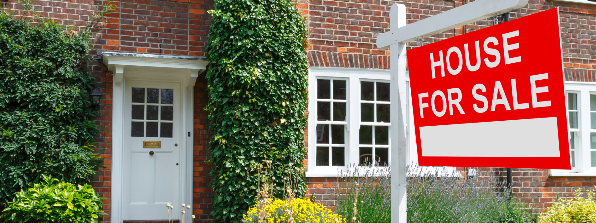 A home for sale in the UK with a for sale sign outside